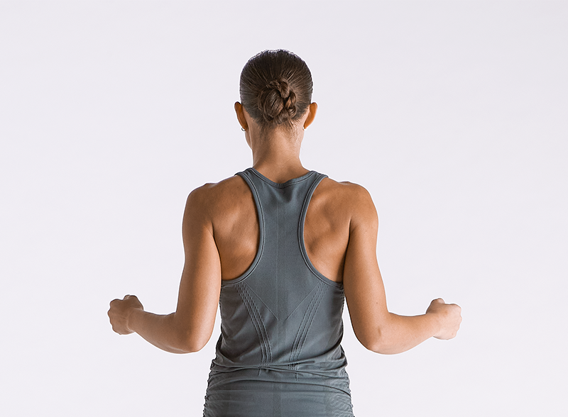  Woman performing shoulder blade squeezes to warm up her shoulders.