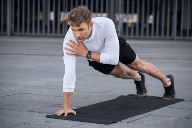 Fitness enthusiast performing shoulder taps, a stabilizing bodyweight shoulder exercise.